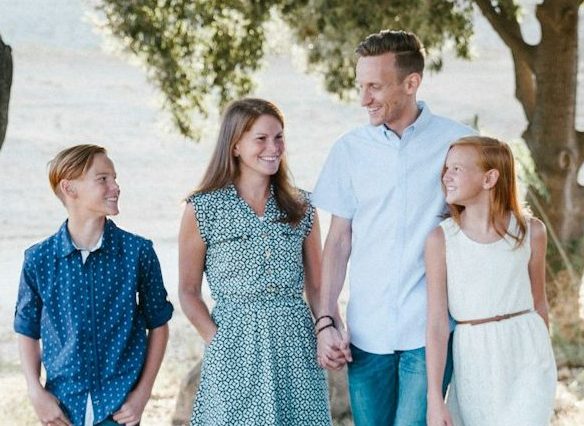 family standing in front of trees